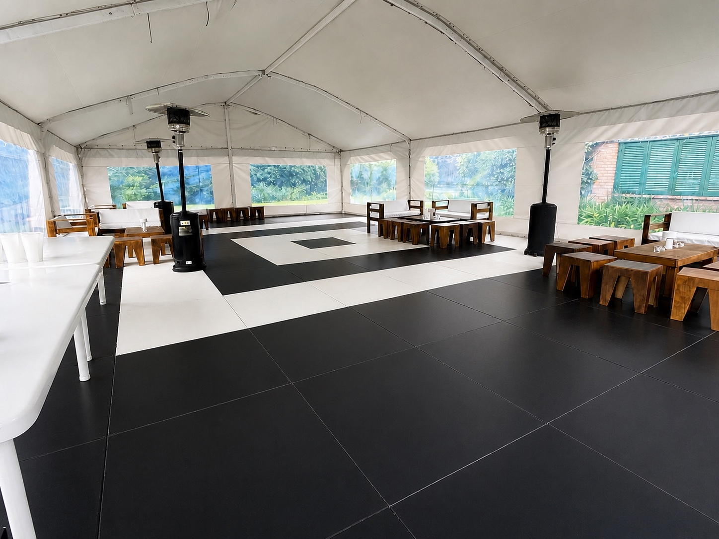 Interior real de carpa con piso negro y damero limpio, livings y calefactores