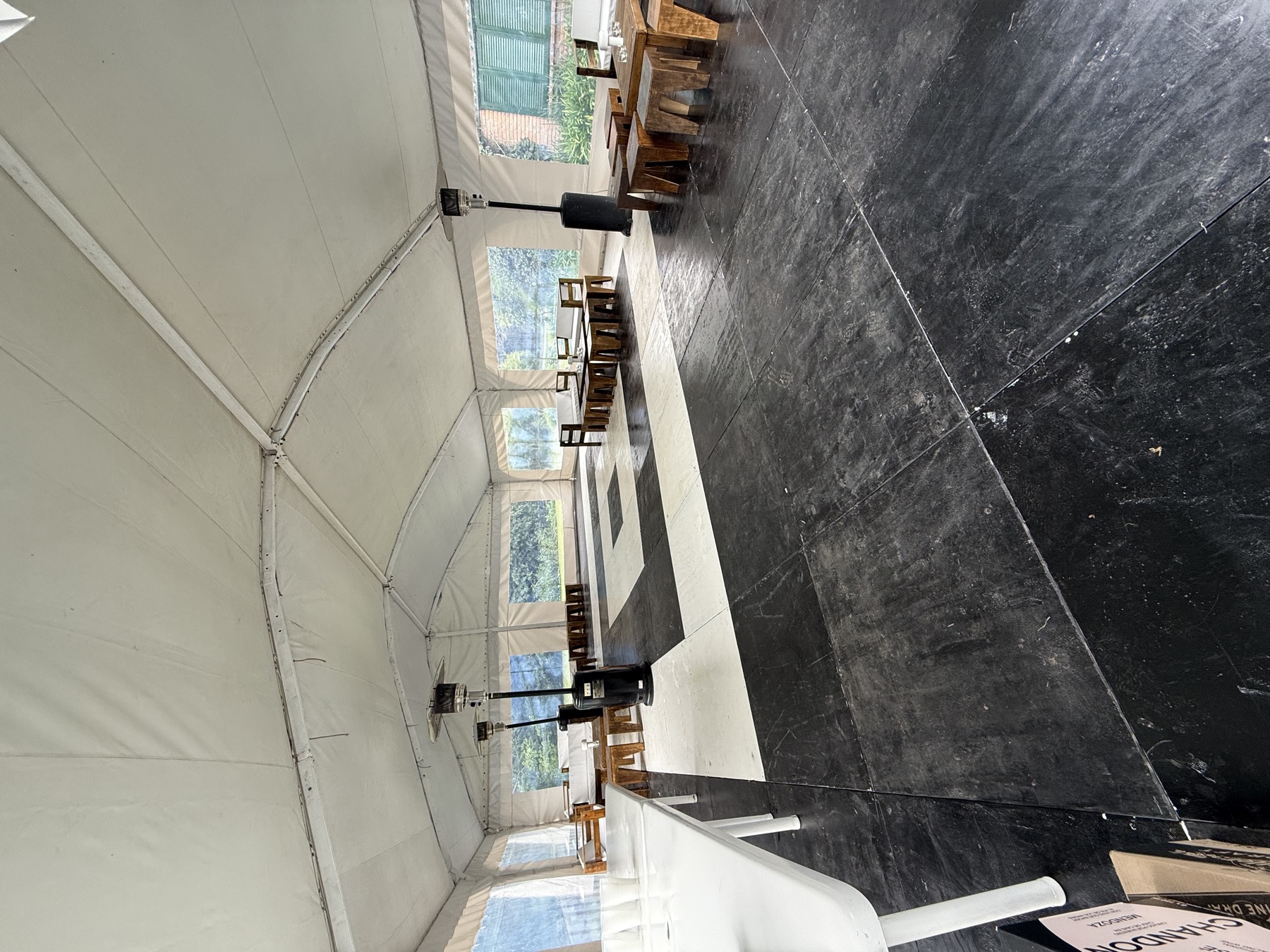 Interior real de carpa con piso negro, sector damero, livings y calefactores